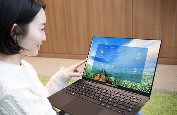 삼성디스플레이 직원이 터치 일체형 OLED가 적용된 노트북 컨셉 제품을 손으로 작동시키고 있는 모습1.png
